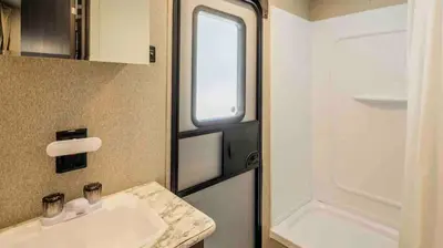 a small bathroom with a sink and a window at Parked RV Travel Trailer Getaway Wi-Fi with Hookups in Fresno