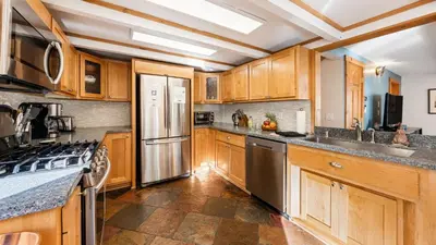 a kitchen with wooden cabinets and stainless steel appliances at Year-Round Tahoe Escape with Hot Tub Outdoor Dining Timberline Haven by AvantStay in Tahoe Vista