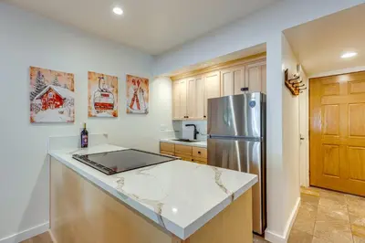 a kitchen with a counter and a refrigerator at Walk to Mammoth Village Chic Mountain Studio in Mammoth Lakes