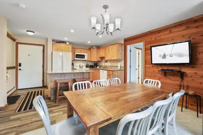 a kitchen and dining room with a wooden table and chairs at 2 Bedroom Kirkwood Condo – Across the Street from Village condo in Kirkwood