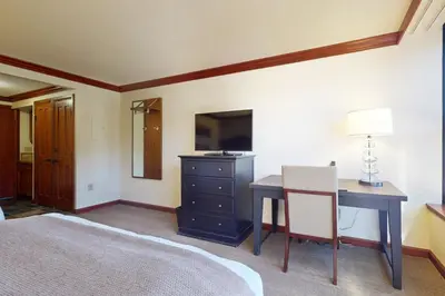 a bedroom with a desk and a bed and a television at Everline Resort & Spa 630 in Olympic Valley