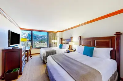 a hotel room with two beds and a flat screen tv at Everline Resort & Spa 812 in Olympic Valley