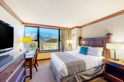 a hotel room with a bed and a desk and a window at Everline Resort & Spa 812 in Olympic Valley