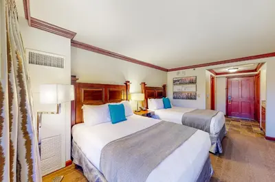 a hotel room with two beds with blue pillows at Everline Resort & Spa 812 in Olympic Valley