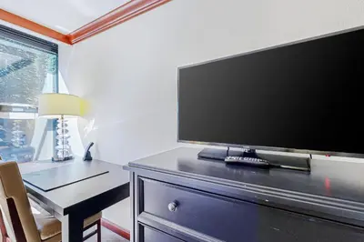 a flat screen tv sitting on a dresser with a table at Everline Resort & Spa 523 in Olympic Valley