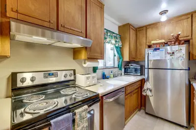 a kitchen with a stainless steel refrigerator and wooden cabinets at Quiet Truckee Retreat with Deck, 5 Mi to Donner Lake in Truckee