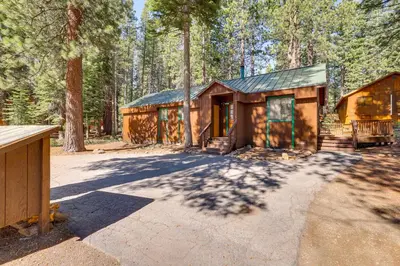 a log cabin in the woods with a driveway at Quiet Truckee Retreat with Deck, 5 Mi to Donner Lake in Truckee