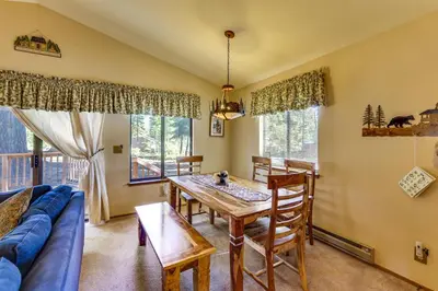 a living room with a table and a blue couch at Quiet Truckee Retreat with Deck, 5 Mi to Donner Lake in Truckee