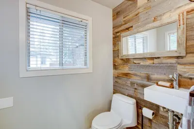 a bathroom with a white toilet and a wooden wall at Work and Play! Lake Tahoe Cabin 5 Mi to Heavenly Mtn in South Lake Tahoe