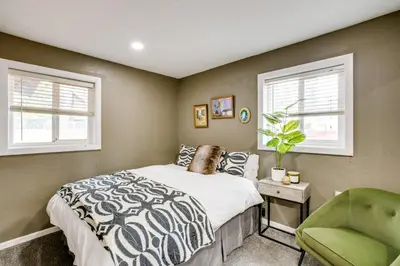 a bedroom with a bed and a green chair at Work and Play! Lake Tahoe Cabin 5 Mi to Heavenly Mtn in South Lake Tahoe