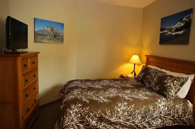 a bedroom with a bed with a television and a dresser at Eagle Run # 204 in Mammoth Lakes