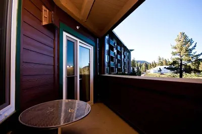a patio with a table and a window on a building at Juniper Springs Lodge # 203 in Mammoth Lakes