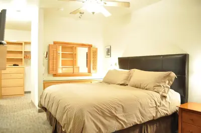 a bedroom with a large bed with a black headboard at Juniper Springs Lodge # 203 in Mammoth Lakes