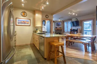 a kitchen with a refrigerator and a table with chairs at Juniper Springs Lodge # 426 in Mammoth Lakes