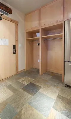 an empty kitchen with a refrigerator and shelves at Juniper Springs Lodge # 426 in Mammoth Lakes