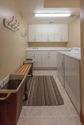 a kitchen with white cabinets and a bench in it at Timbers # 1033 in Mammoth Lakes
