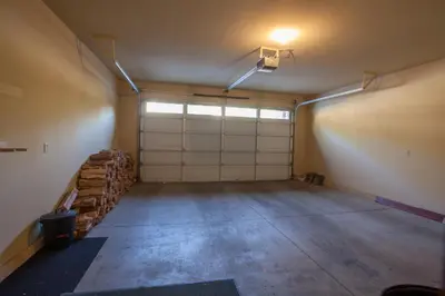 a garage with two garage doors and a pile of logs at Timbers # 1033 in Mammoth Lakes