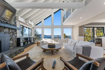 a living room with white furniture and a stone fireplace at HCH0868 - The Grand Escape home in South Lake Tahoe