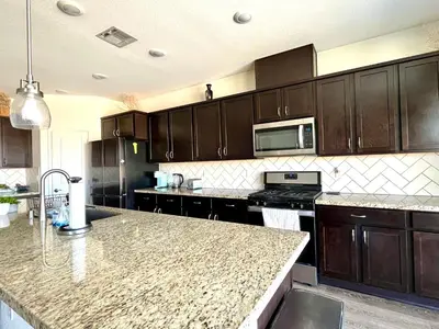 a kitchen with wooden cabinets and a granite counter top at \u8212\u670d\u5bbd\u655e\u7684\u7a7a\u95f4