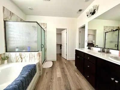 a large bathroom with a tub and a sink at \u8212\u670d\u5bbd\u655e\u7684\u7a7a\u95f4