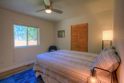 a bedroom with a bed with a ceiling fan and a window at NVH0823 - Sadies Hustle home in Zephyr Cove