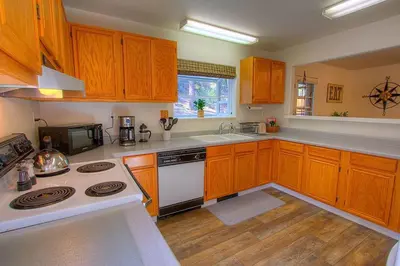 a kitchen with wooden cabinets and a white stove top oven at NVH0823 - Sadies Hustle home in Zephyr Cove