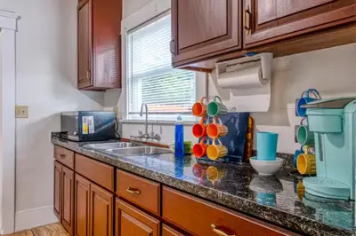 a kitchen with wooden cabinets and a counter top at 2BR Family Getaway with Yard Kitchen and Parking in Lodi