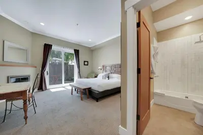 a bedroom with a bed and a bathroom with a tub at Hanford House in Sutter Creek