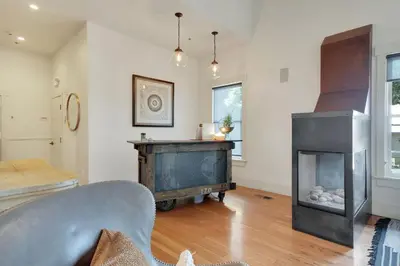 a living room with a fireplace and a chair at Hanford House in Sutter Creek