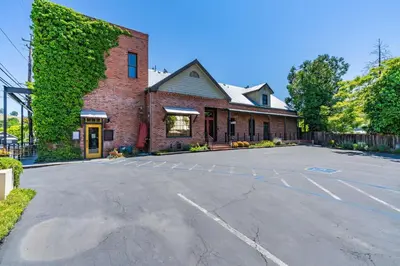 an empty parking lot in front of a brick building at Hanford House in Sutter Creek