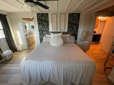 a bedroom with a white bed with a cat sitting on it at Scenic Ranch Retreat Near Fresno in Fresno