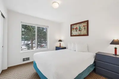 a white bedroom with a bed and a window at 3 Bedroom Kirkwood Condo – Base Camp condo in Kirkwood