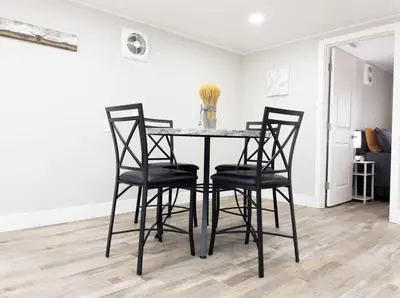 a dining room table with four black chairs at Country Living 3BR with fenced yard on Mooney in Visalia