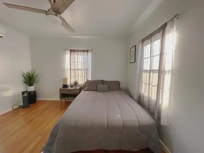 a bedroom with a large bed with a ceiling fan at Sequoia Basecamp With Fenced Yard in Visalia
