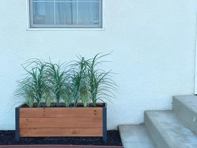 a wooden planter with plants in it next to a building at Sequoia Basecamp With Fenced Yard in Visalia