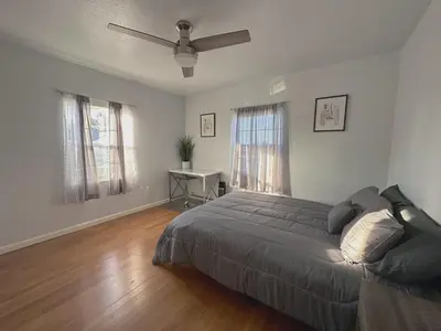 a bedroom with a bed and a ceiling fan at Sequoia Basecamp With Fenced Yard in Visalia