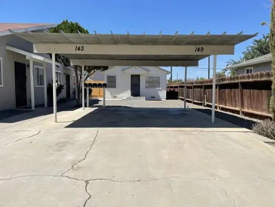 a covered parking lot with a white house at Lovely home central Coalinga-2BR Stopover near I-5 in Coalinga