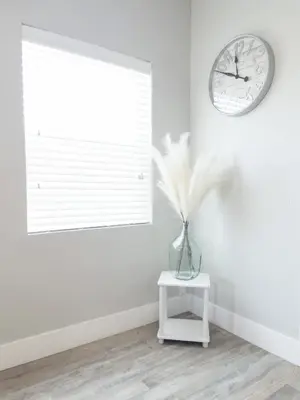 a white room with a vase on a table and a clock at Ocean Breeze 2 bedroom w fenced yard on Mooney in Visalia