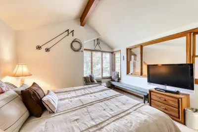 a bedroom with a large bed and a flat screen tv at Sierra Megeve 16 in Mammoth Lakes