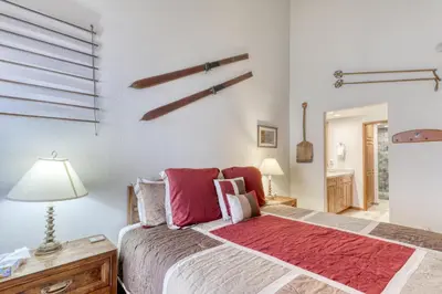 a bedroom with a large bed with a red rug at Sierra Megeve 16 in Mammoth Lakes