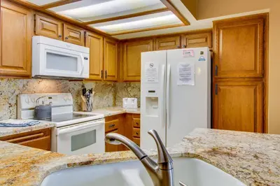 a kitchen with white appliances and wooden cabinets at Sierra Megeve 13 in Mammoth Lakes