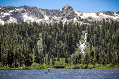 two people in a lake with mountains in the background at Sierra Megeve 13 in Mammoth Lakes