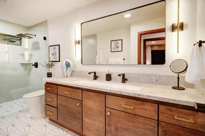 a bathroom with a sink and a large mirror at Elegant Granite Bay Getaway Tall Pine Home in Granite Bay