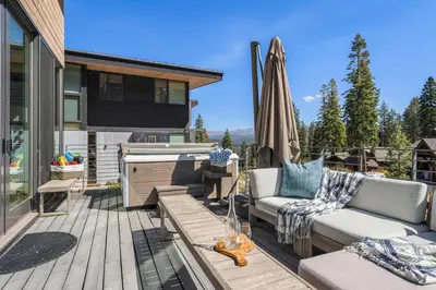 a patio with a couch and a tub on a deck at Northstar Ski-In Ski-Out Luxury Townhome with Hot Tub in Truckee