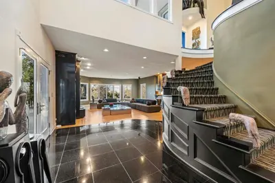 a living room with a staircase with chairs and a lobby at Vista De Lago Retreat Luxury Mansion with Pool and Theater in Granite Bay