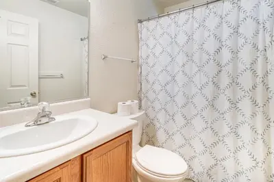 a bathroom with a sink and a toilet and a shower curtain at Hike, Swim, Golf Family Retreat in Arnold! in Arnold