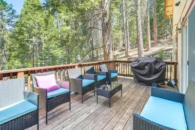 a deck with chairs and tables in the woods at Hike, Swim, Golf Family Retreat in Arnold! in Arnold