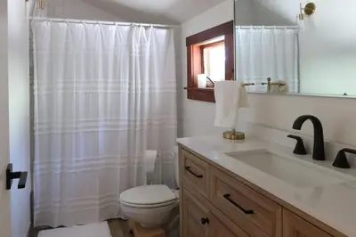 a bathroom with a white shower curtain and a toilet at Walk to Lake 4BR Memory Making Alpine Retreat in Tahoe City