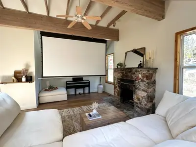 a living room with a white couch and a large screen at Walk to Lake 4BR Memory Making Alpine Retreat in Tahoe City