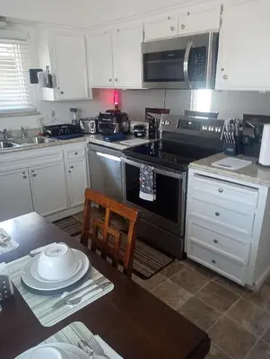 a kitchen with a stove and a table with plates on it at Franklin Apt in Fresno